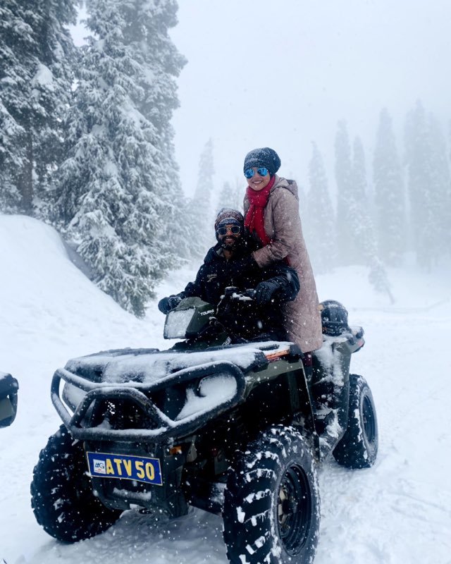 Two travellers on a quad bike in heavy snowfall